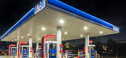 Estación de servicio Mobil de noche con 6 bombas de gasolina disponibles.