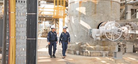 Trabajadores de servicio de campo caminando dentro de una refinería